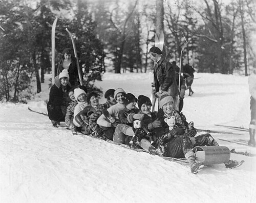 a group of nine young people on a long toboggan