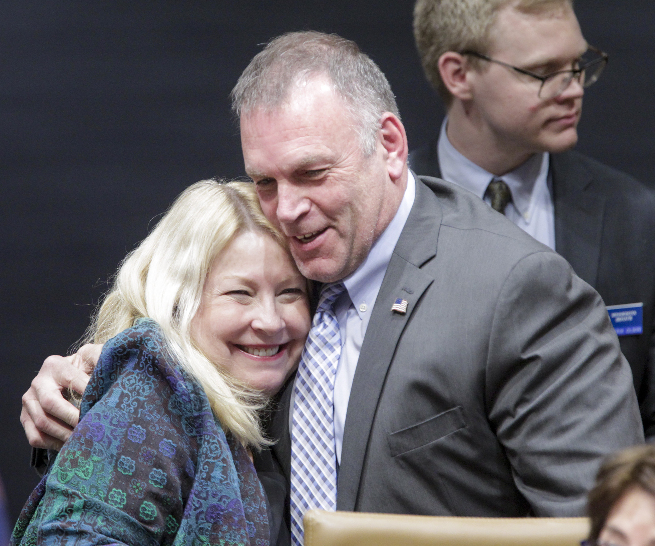 Representative Baker and Senator Eaton hug each other on their sides.