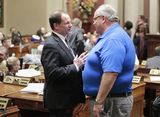 Representative Marquart and Representative Davids stand to have a conversation with each other on the House Floor.