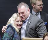 Representative Baker and Senator Eaton hug each other on their sides.