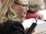 Representative Halverson holds her phone below her face, and a tiny fan is attached to it.
