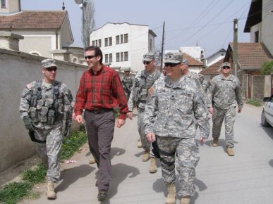 Governor Tim Pawlenty on a walking tour of Vitina, Kosovo with CPT Jeff Blowers, from St. Cloud, Min...